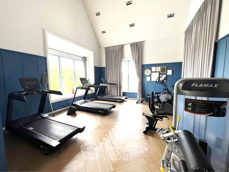 Modern gym with treadmills and exercise equipment in a bright, spacious room.