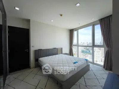 Spacious bedroom with city view and modern furnishings in high-rise apartment