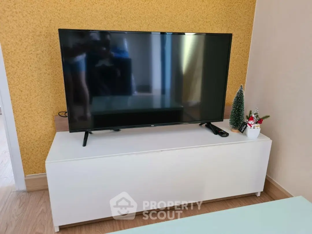 Modern living room with sleek TV setup and festive decor