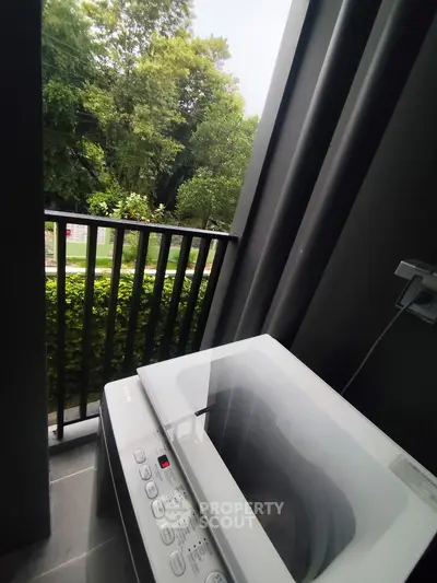 Modern balcony with washing machine and lush green view