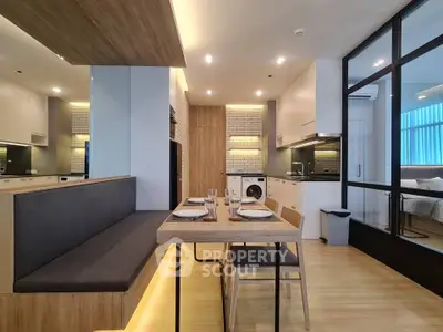 Modern open-layout kitchen with dining area and stylish lighting in a contemporary apartment.