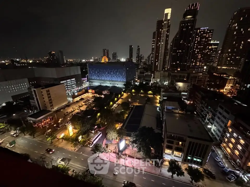 Stunning cityscape view from high-rise building at night with illuminated skyline and bustling streets.