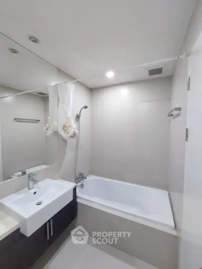 Modern bathroom with sleek design featuring a bathtub and stylish sink.