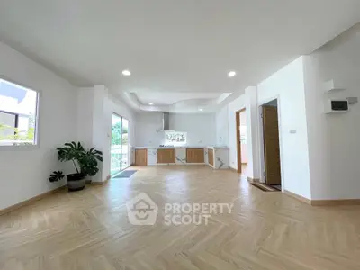 Spacious open-plan living room with modern kitchen and natural light