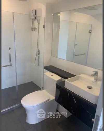 Modern bathroom with sleek design, glass shower, and stylish fixtures.