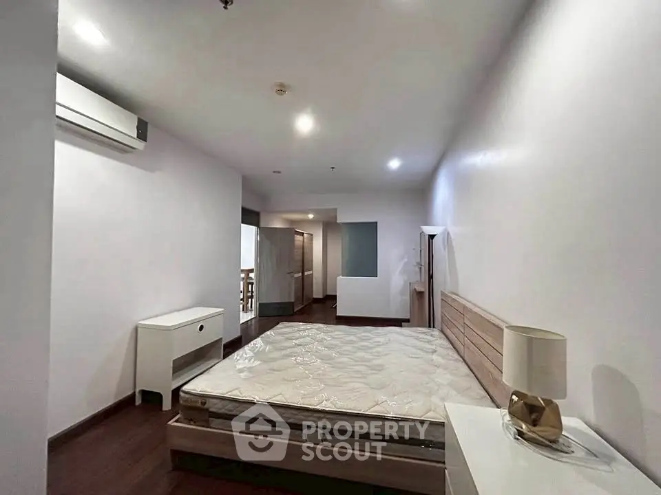 Spacious bedroom with modern furnishings and ample natural light.