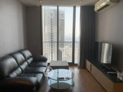 Modern living room with leather sofa and city view through large windows
