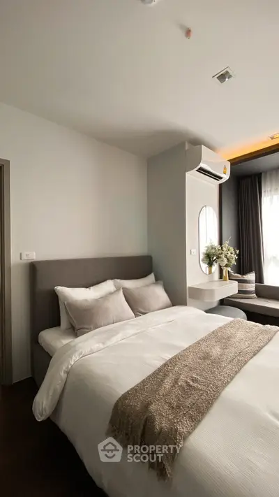 Modern bedroom with cozy bedding and stylish decor in a contemporary apartment.