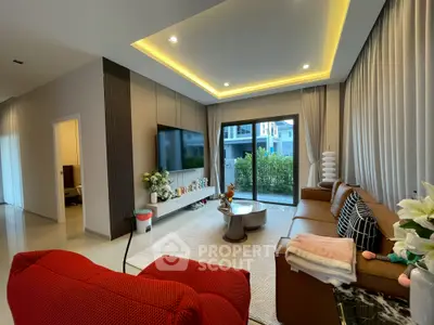 Modern living room with stylish decor, large TV, and garden view through sliding doors.