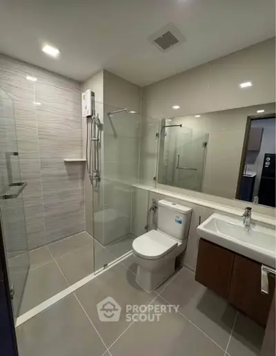 Modern bathroom with glass shower and sleek fixtures in a contemporary home.