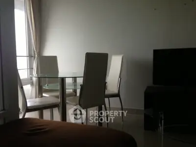 Modern living room with glass dining table and sleek chairs, perfect for urban living.