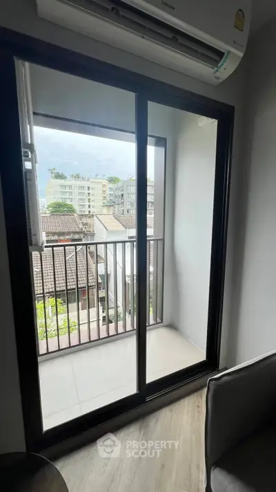 Charming apartment balcony with scenic city view and modern sliding glass doors.