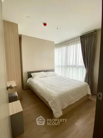 Modern bedroom with large window and minimalist design in a high-rise apartment.