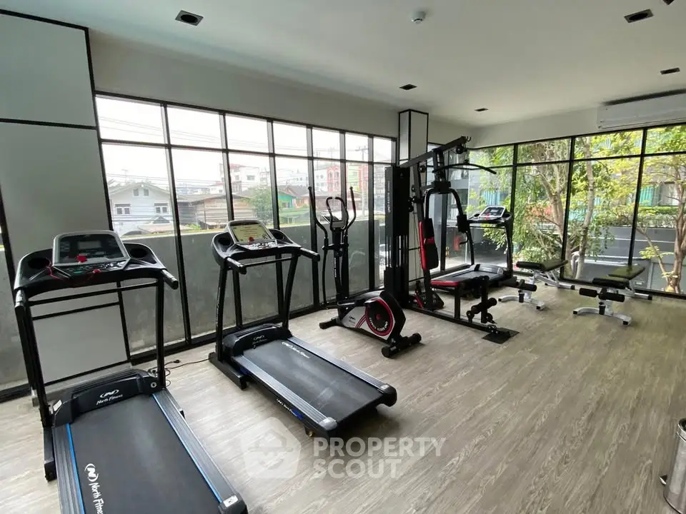 Modern gym with state-of-the-art equipment and large windows for natural light.