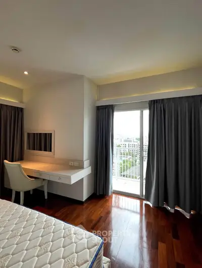Spacious bedroom with balcony access and elegant wooden flooring