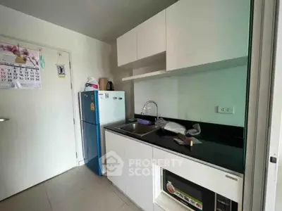 Modern compact kitchen with sleek cabinetry and built-in appliances in a cozy apartment.