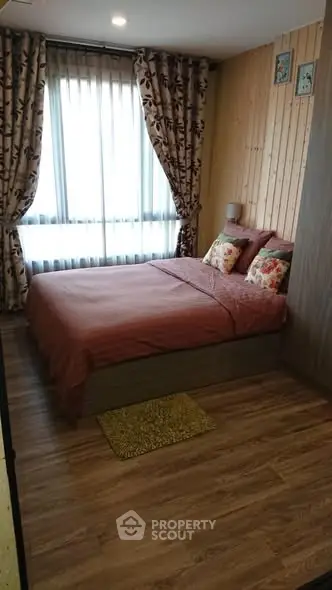 Cozy bedroom with wooden accents and large window for natural light