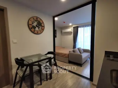 Modern studio apartment with open layout, featuring a cozy living area and stylish dining space.