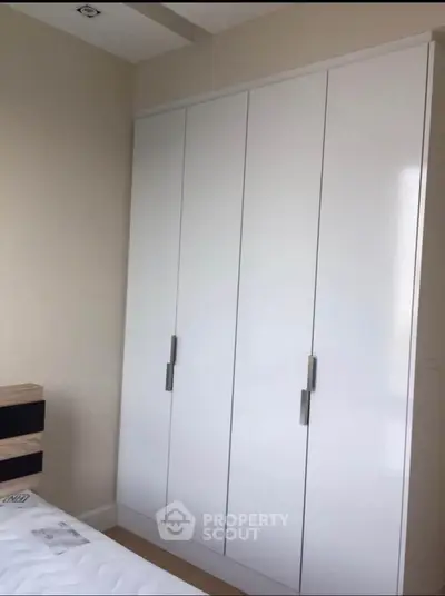 Modern bedroom with sleek white wardrobe and minimalist design