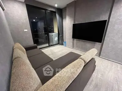 Modern living room with large sofa and wall-mounted TV, featuring a balcony view.