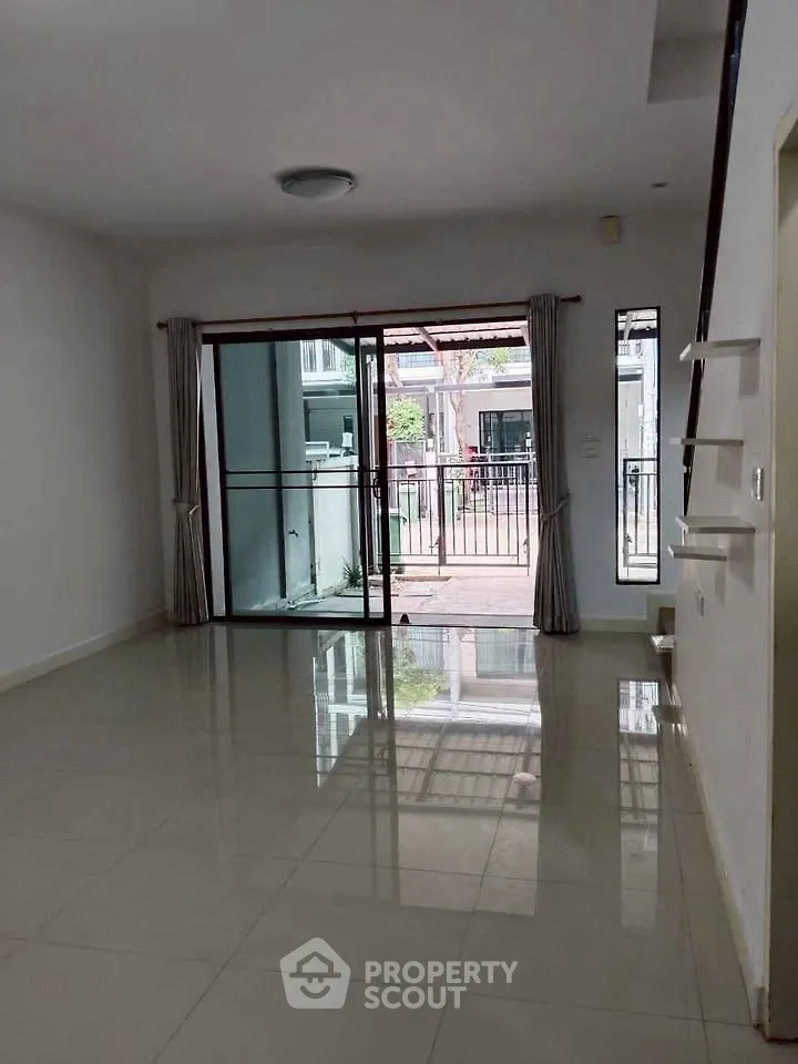 Spacious living room with sliding glass doors leading to a balcony, perfect for natural light and outdoor access.