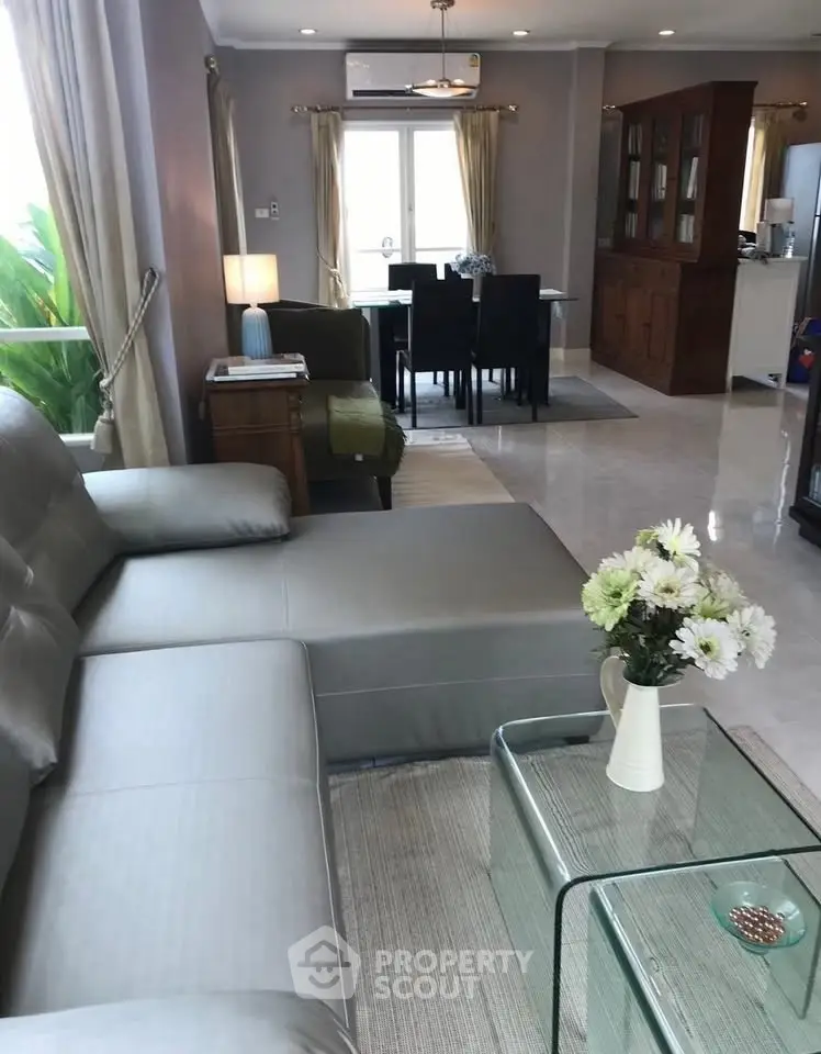 Spacious living room with modern furniture and dining area in open layout.