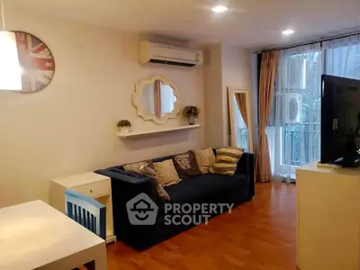 Charming living room with modern decor and natural light, featuring a cozy sofa and stylish wall mirror.
