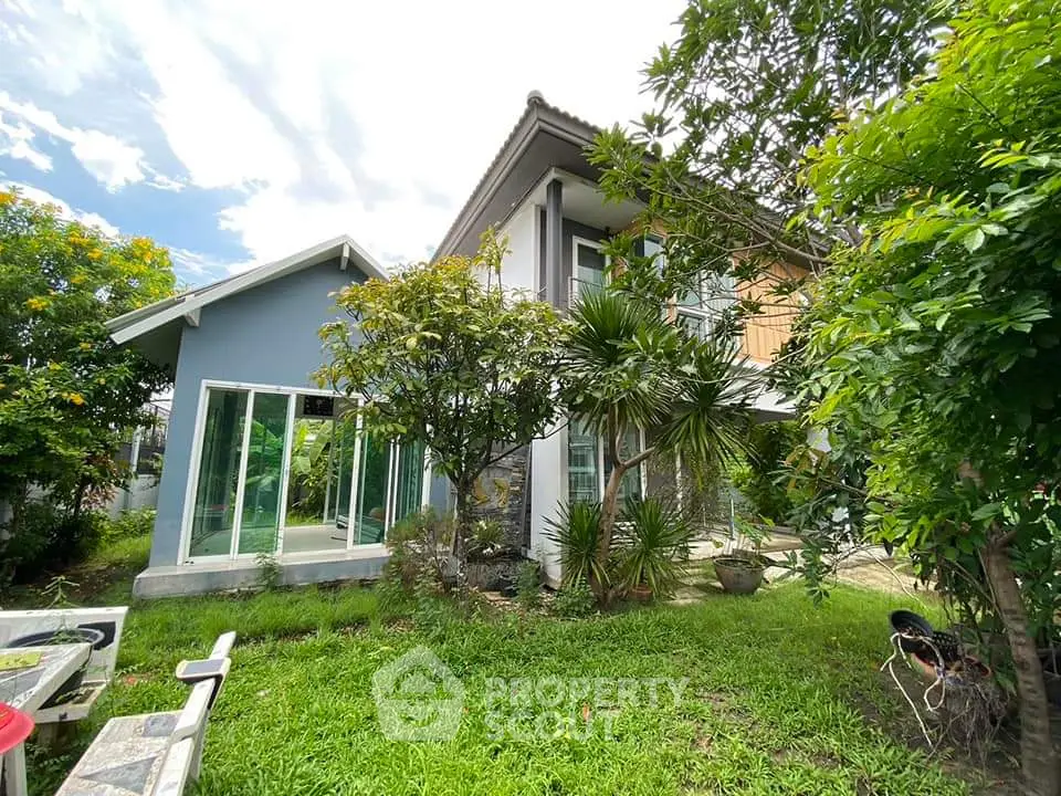 Charming two-story house with lush garden and modern glass extension