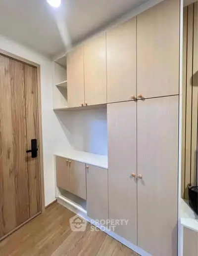 Modern storage cabinets in a stylish apartment entryway with wooden flooring.