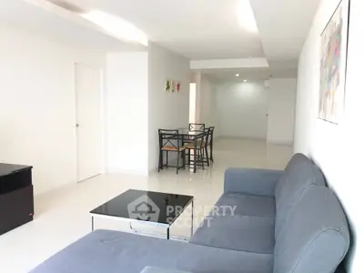 Spacious modern living room with sleek furniture and dining area in open layout.