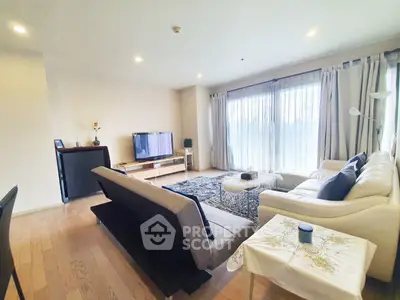 Spacious living room with modern decor and large windows offering natural light.