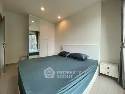 Modern bedroom with sleek design and large window offering natural light