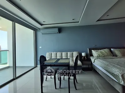 Modern studio apartment with sleek design, featuring a cozy bed, stylish dining area, and large balcony access.