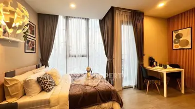 Modern bedroom with stylish decor and cozy dining area, featuring large windows and elegant lighting.