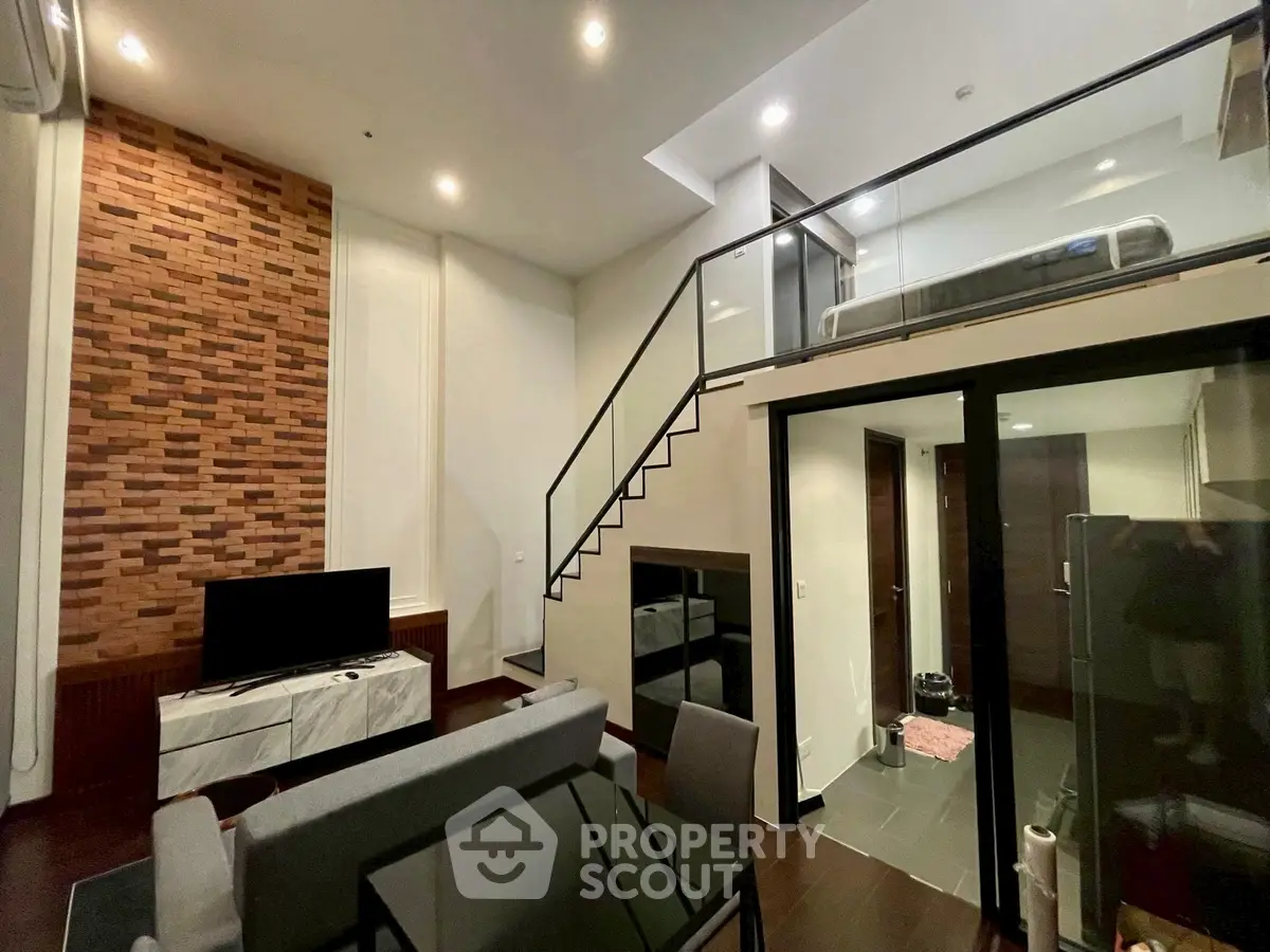 Modern loft-style living room with mezzanine and brick accent wall