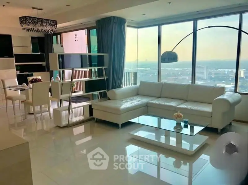 Luxurious modern living room with panoramic city view and elegant white furniture.