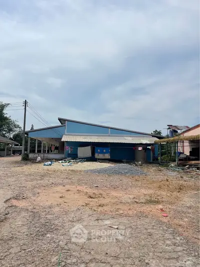 Spacious industrial property with ample outdoor space and unique architectural design.