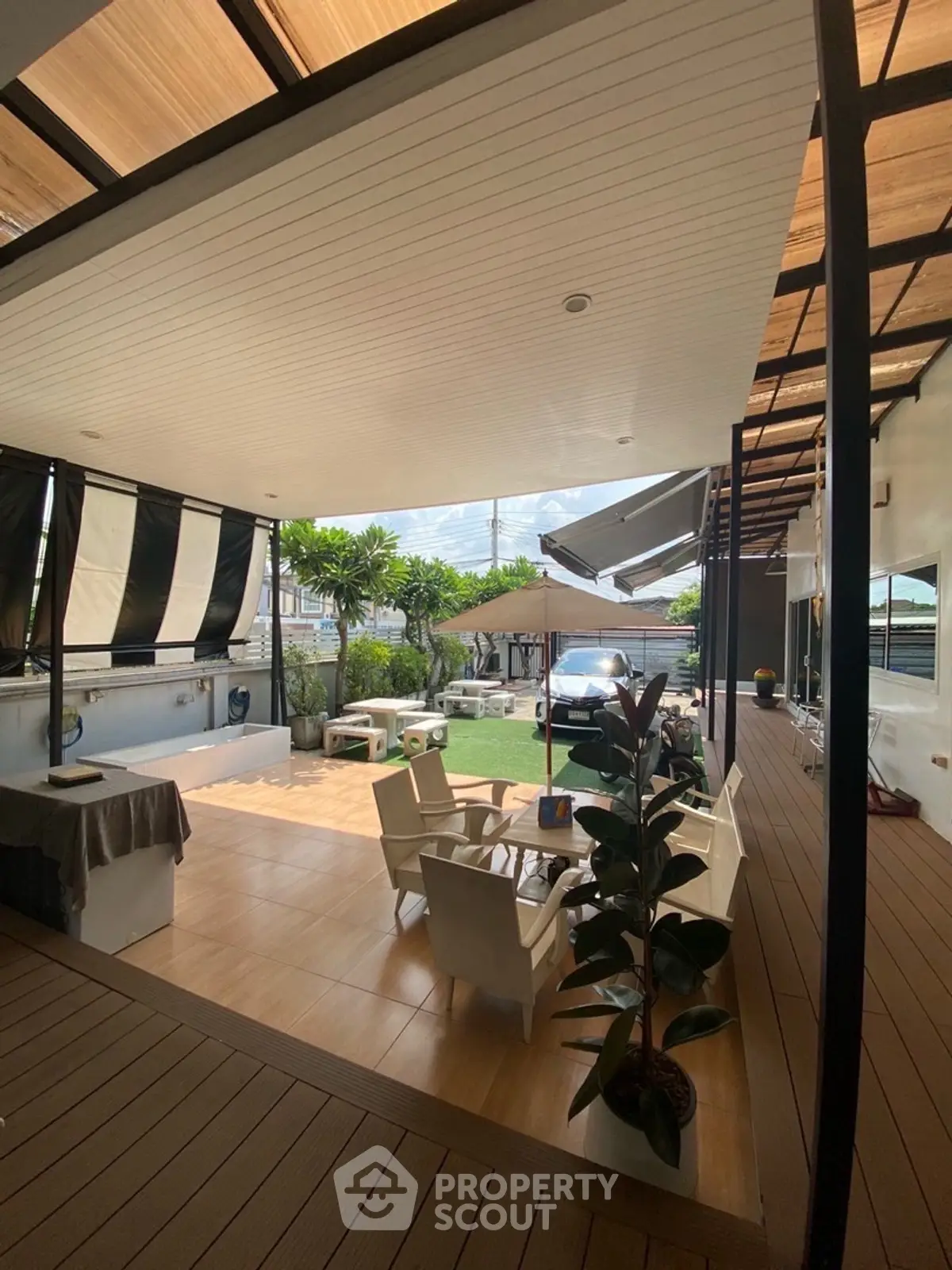 Spacious outdoor patio with modern seating and lush garden view