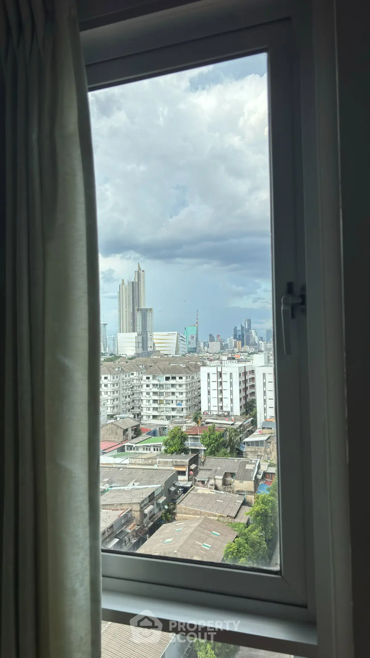 Stunning cityscape view from a high-rise apartment window, showcasing urban skyline and vibrant city life.
