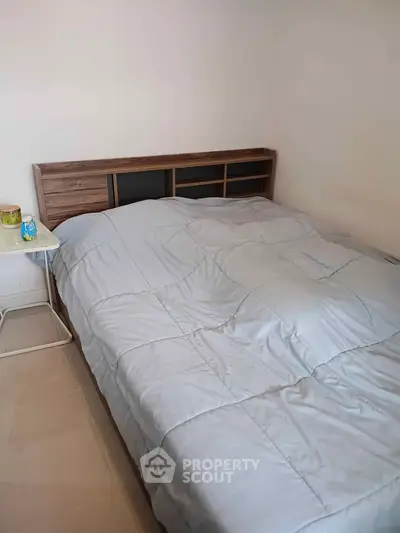 Cozy bedroom with modern wooden headboard and soft bedding, perfect for restful nights.