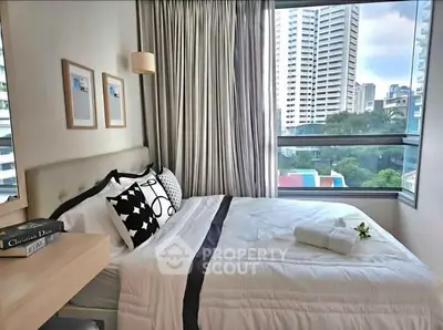 Modern bedroom with city view, featuring elegant decor and large windows for natural light.