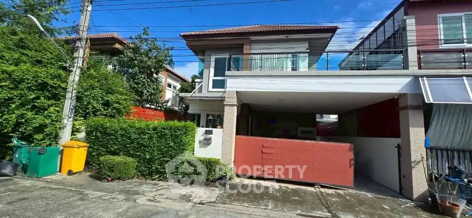Charming two-story house with a spacious garage and lush greenery in a serene neighborhood.