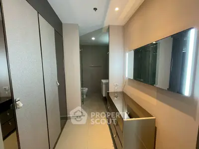 Modern bathroom with sleek cabinetry and illuminated mirror in luxury apartment.