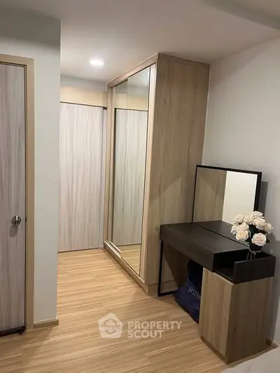 Modern bedroom with sleek wooden flooring and stylish wardrobe design.