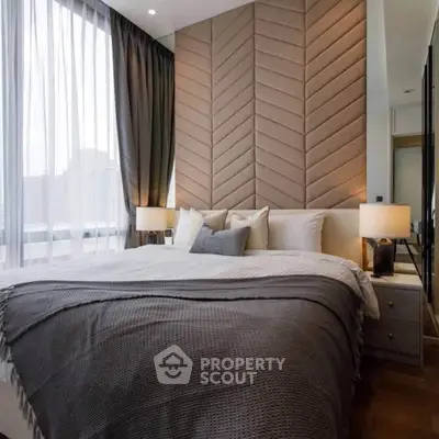 Luxurious bedroom with elegant decor and large windows offering natural light.