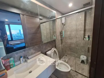 Modern bathroom with glass shower and city view from window, featuring sleek design and elegant fixtures.