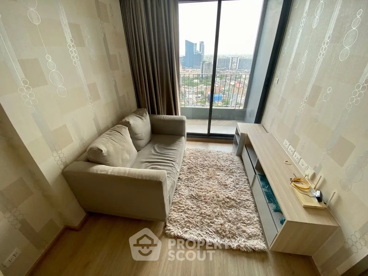 Cozy living room with plush sofa and city view from large window balcony.
