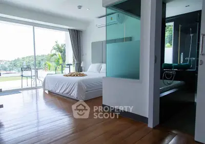 Luxurious bedroom with balcony and scenic view, featuring modern design and elegant wooden flooring.