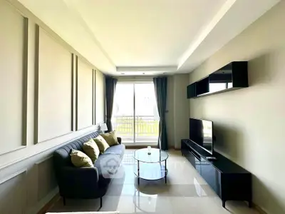 Modern living room with sleek furniture and large window offering natural light