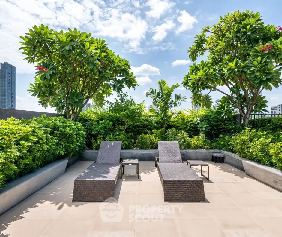 Luxurious rooftop terrace with sun loungers and lush greenery offering a serene urban escape.